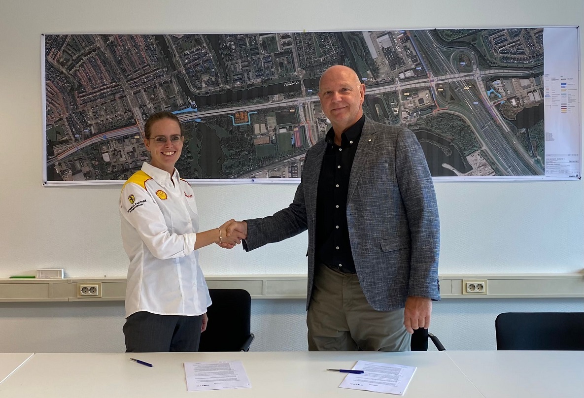 Foto met medewerker Shell en gemeente Zaanstad die elkaar handschudden na tekenen overeenkomst